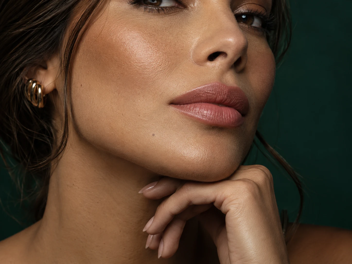 Imagem ilustrativa em close dos lábios de uma modelo adulta, com maquiagem suave e textura natural da pele.